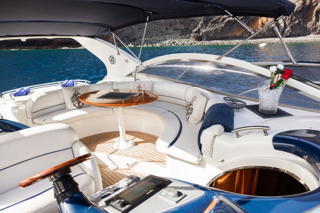 Intérieur de yacht avec sièges en cuir blanc et table ronde sur la côte de Tenerife.