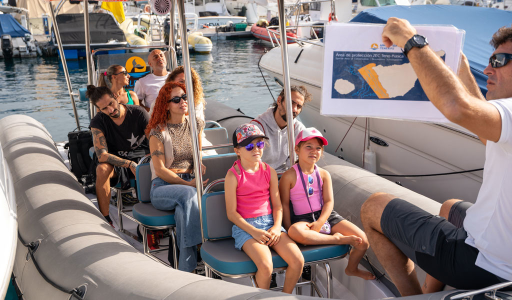 Des personnes sur un bateau à Tenerife, guide montrant la carte de la zone protégée TENO-Rasca SAC.