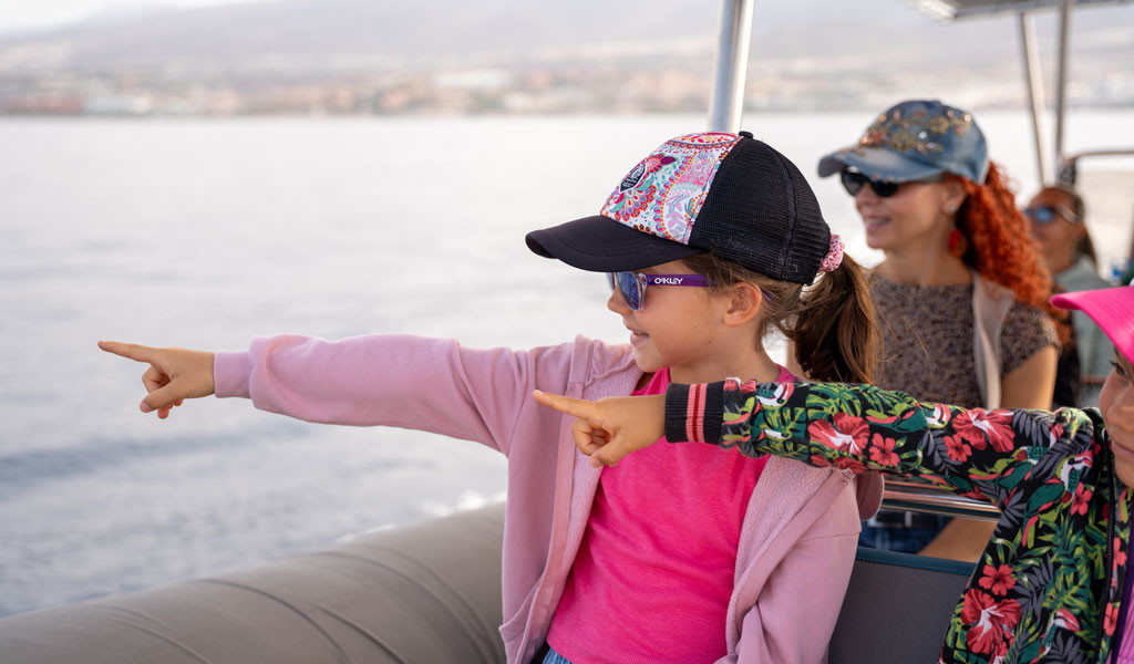 Des filles pointant du doigt depuis un bateau sur la côte de Tenerife.