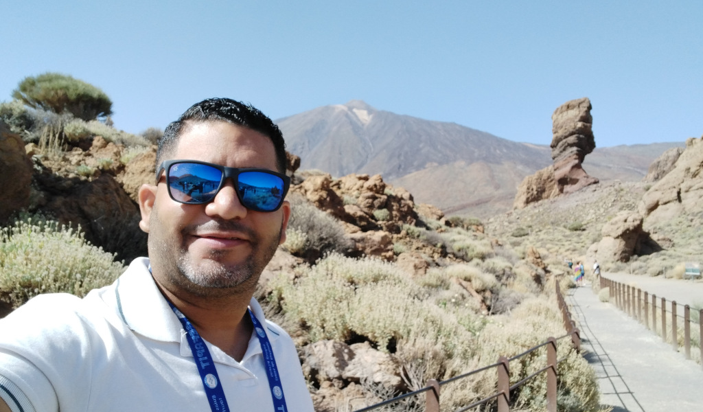 Personne portant des lunettes de soleil dans le parc national du Teide, Tenerife. Montagnes et formations rocheuses derrière.