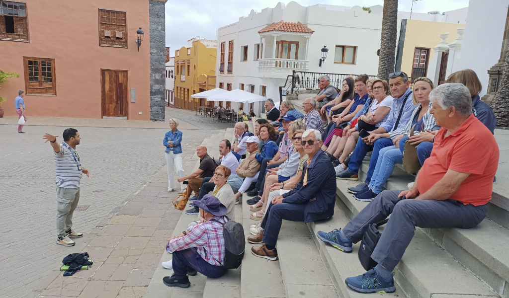 Groupe de touristes sur une place à La Laguna, à Tenerife, écoutant un guide touristique.