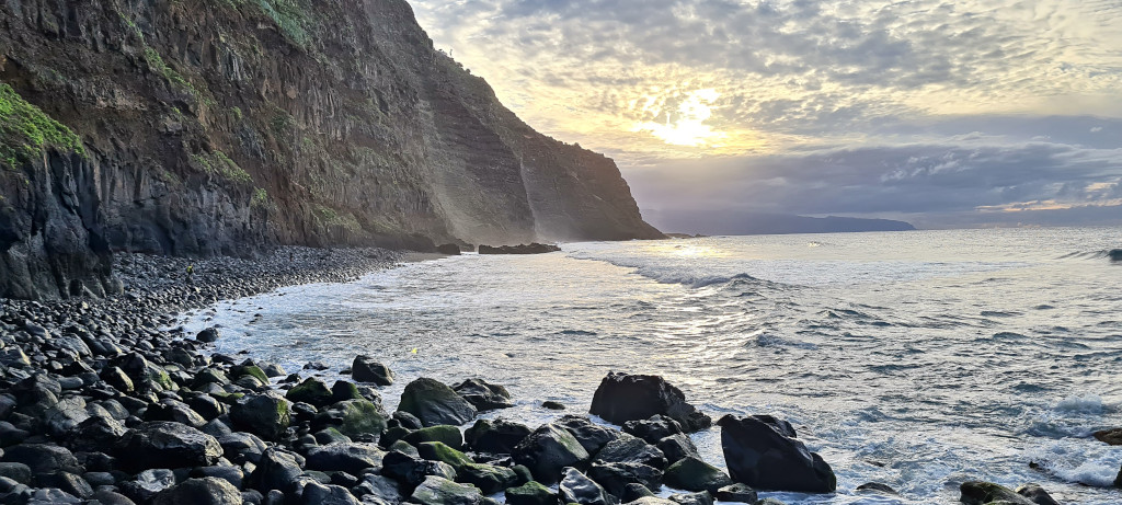 Côte rocheuse au coucher du soleil à Tenerife, avec des falaises et une mer calme.