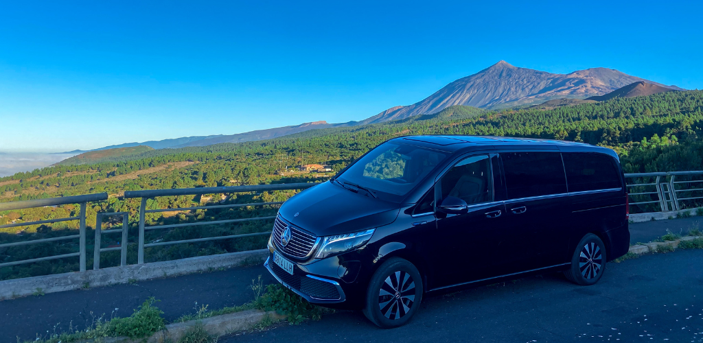 Véhicule noir avec un fond Teide à Tenerife sous un ciel dégagé.