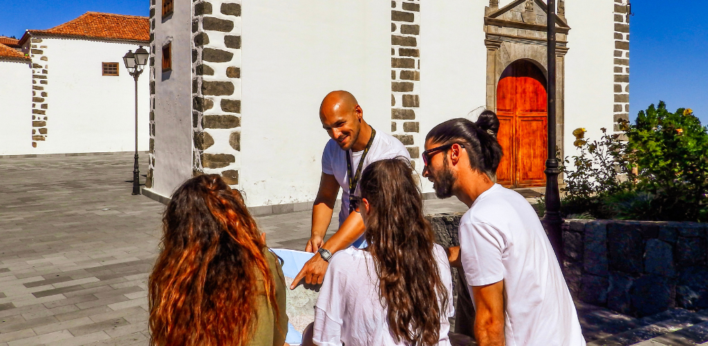 Groupe de personnes regardant une carte devant une église à La Laguna, Tenerife.