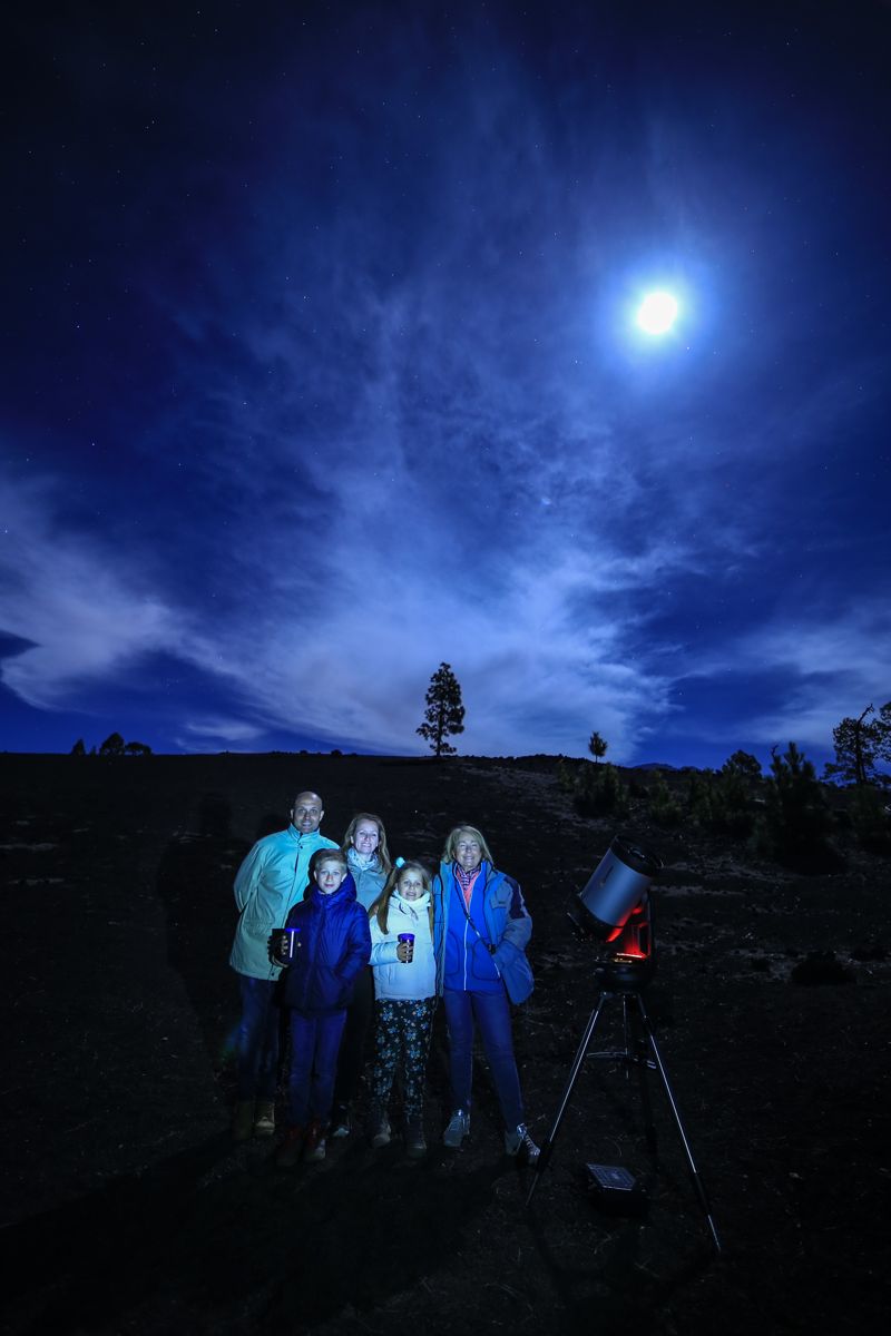 Groupe de personnes avec un télescope observant le ciel nocturne à Tenerife.