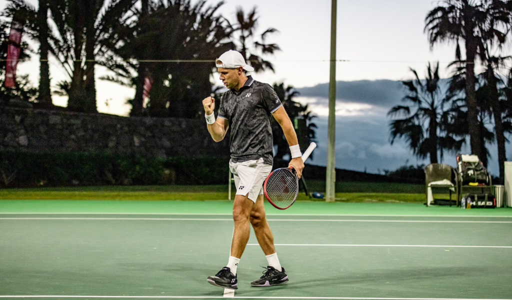 Joueur de tennis célébrant sur le court extérieur à Tenerife au coucher du soleil.