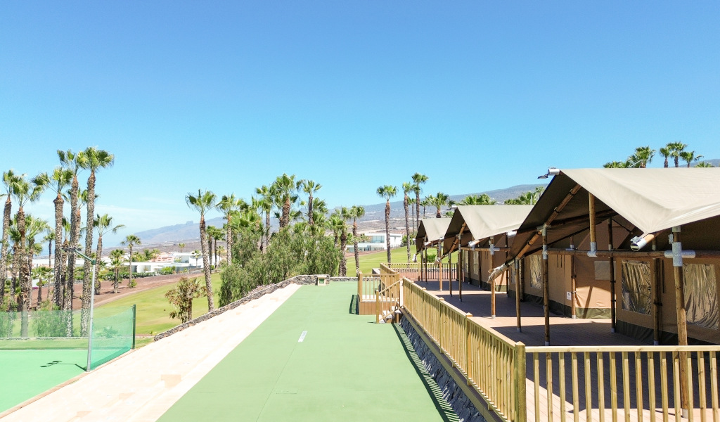 Des cabanes à côté des palmiers et des montagnes dans un complexe à Tenerife.