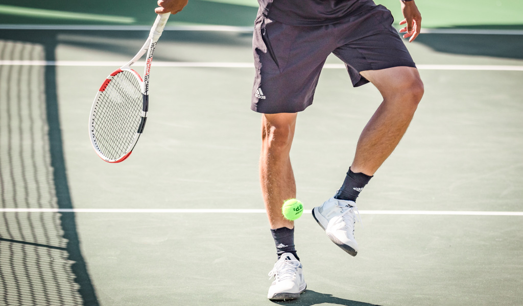 Joueur de tennis sur un court à Tenerife, frappant une balle avec sa raquette.