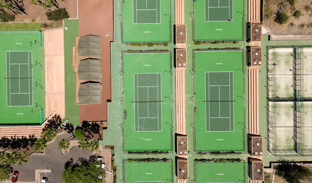 Vue aérienne des courts de tennis à Abama, Tenerife, entourés de verdure et d’aires de repos.