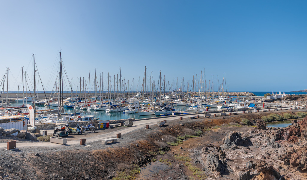 Port de Los Gigantes à Tenerife avec bateaux amarrés et mer bleue.