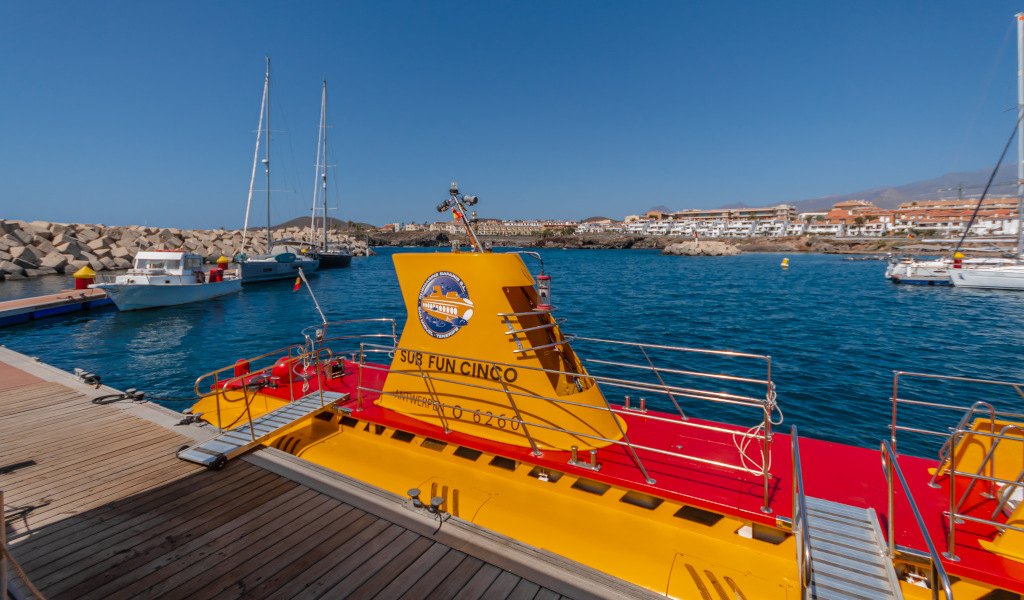 Sous-marin jaune amarré au port de Puerto de la Cruz, à Tenerife, avec des bateaux en arrière-plan.