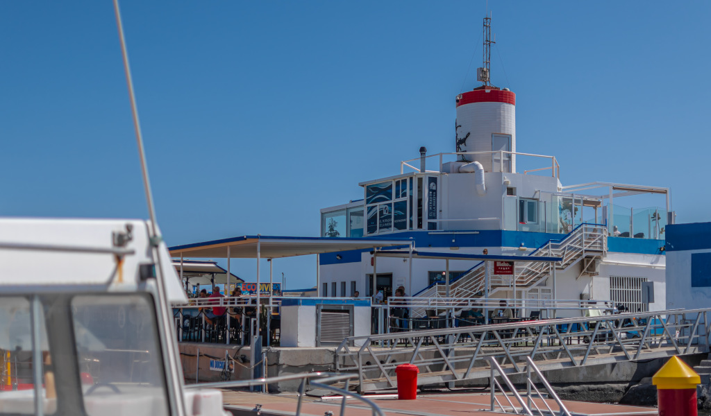 Bâtiment blanc et bleu avec phare rouge à Santa Cruz de Tenerife, vu depuis une jetée.