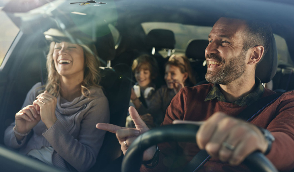 Famille souriante voyageant en voiture à Tenerife.
