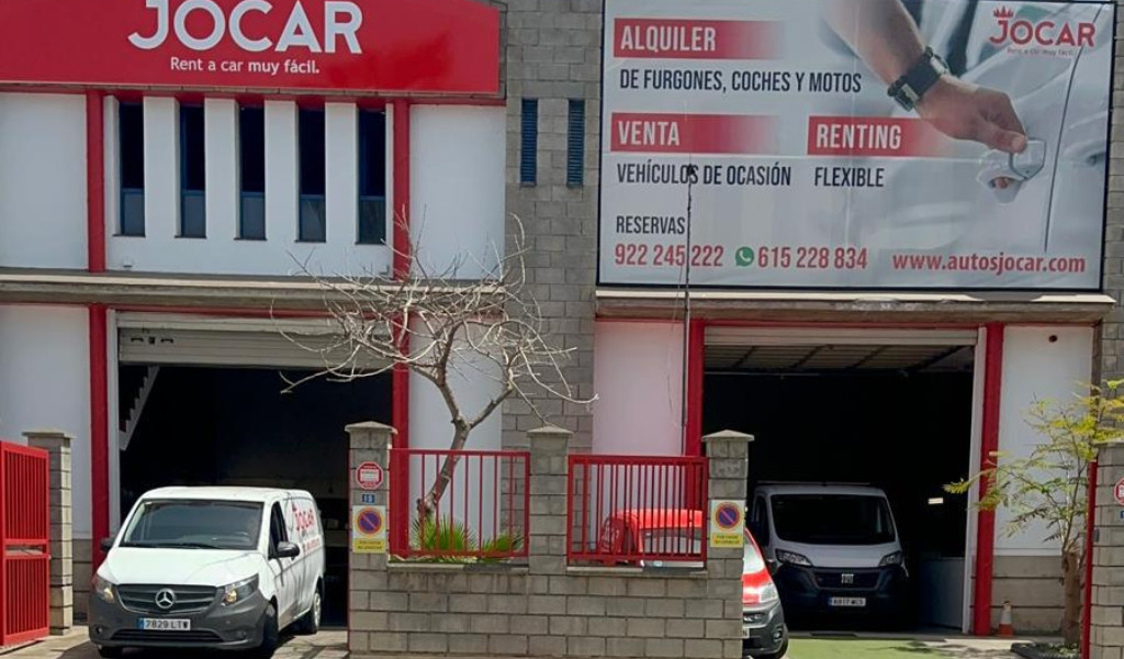 Façade de Jocar à Tenerife avec des publicités pour la location et la vente de véhicules.