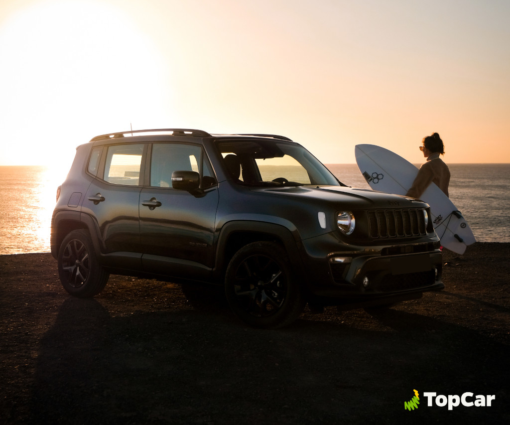Voiture garée au coucher du soleil à côté d’un surfeur sur la côte de Tenerife.