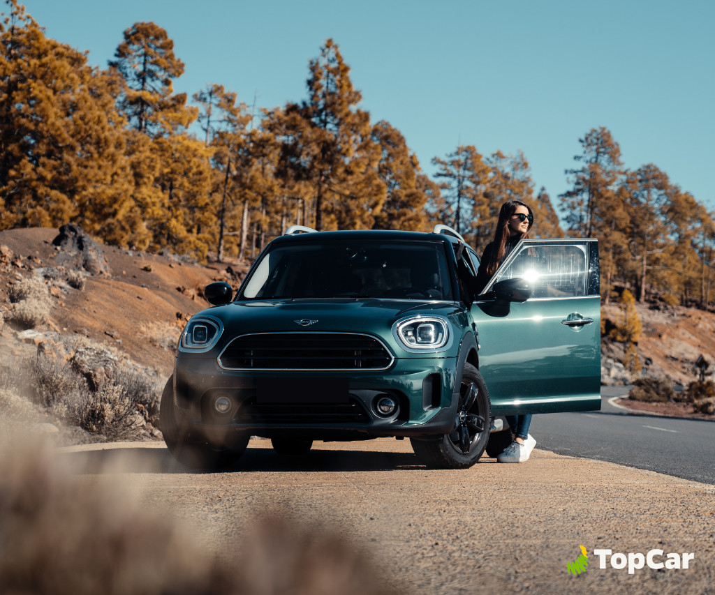 Voiture sur la route de montagne à Tenerife avec une personne près de la porte ouverte.