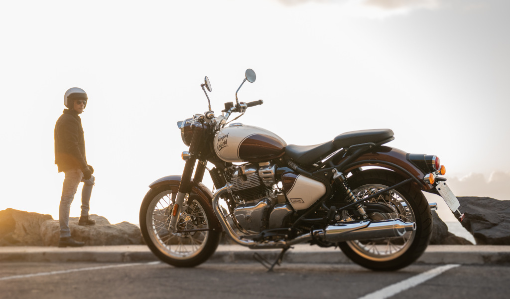 Moto garée avec une personne debout en arrière-plan au coucher du soleil à Tenerife.