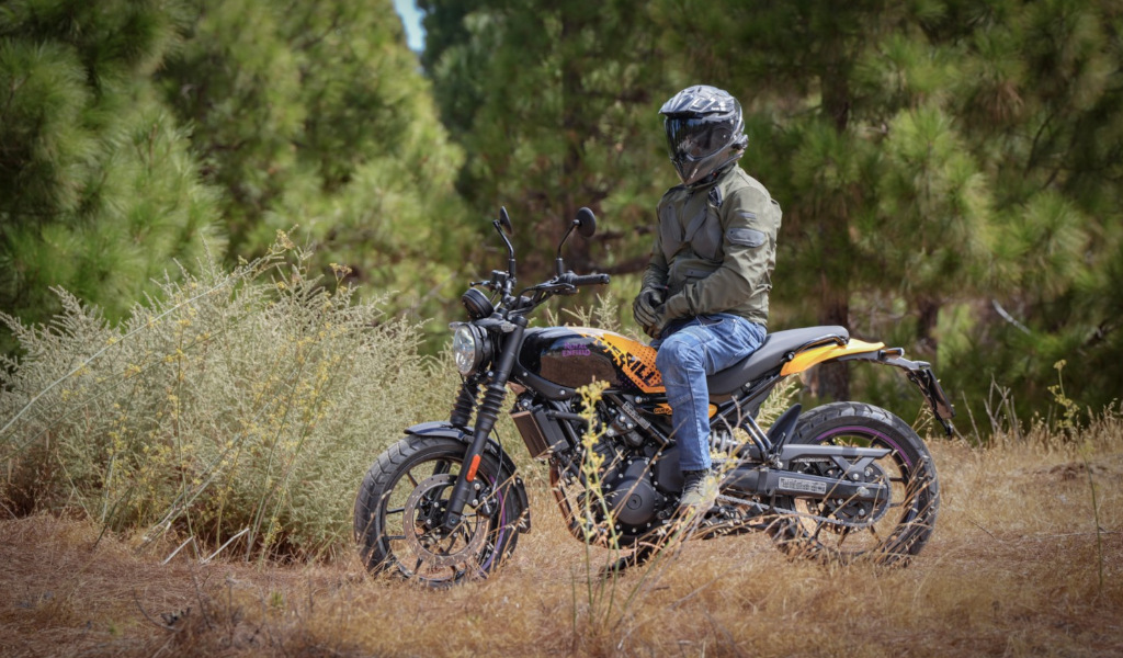 Personne portant un casque assise sur une moto sur une route forestière à Tenerife.