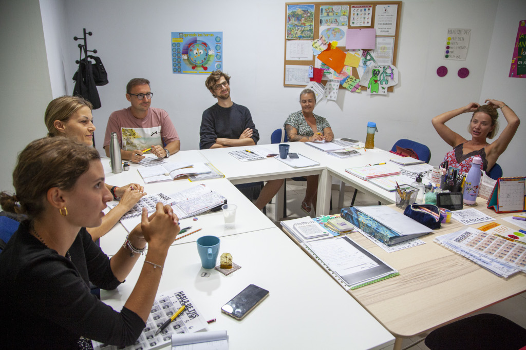 Groupe de personnes à une table de travail dans une classe scolaire à Tenerife.