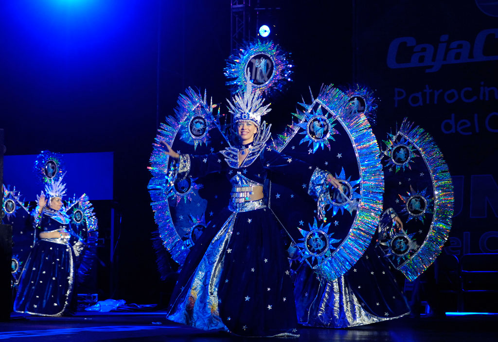 Des femmes en costumes fantastiques éclatants dansant sur une scène à Tenerife.