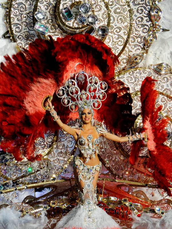 Troupe de carnaval à Tenerife avec un costume éclatant et de grandes plumes rouges.