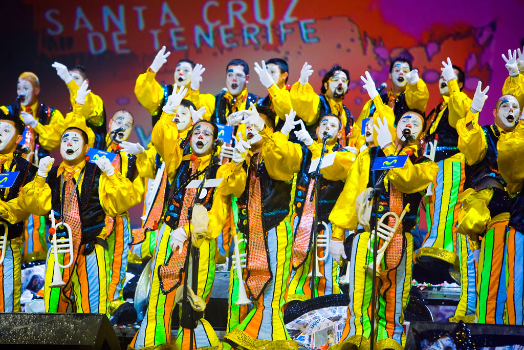 Des gens déguisés en mimes colorés chantent au Carnaval de Santa Cruz de Tenerife.