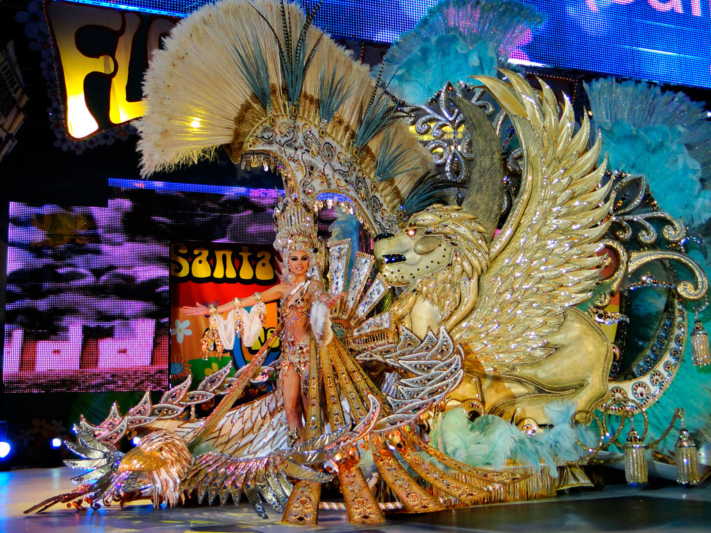 Personnage en costume festif doré avec ornements de plumes et lion ailé à Santa Cruz de Tenerife.