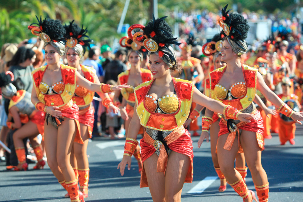 Des gens défilant en costumes colorés au Carnaval de Tenerife.