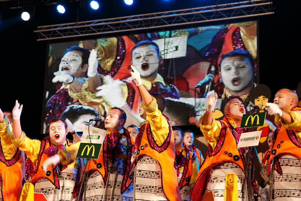 Performance musicale lors d’un carnaval à Tenerife avec des costumes colorés et des chants de groupe.