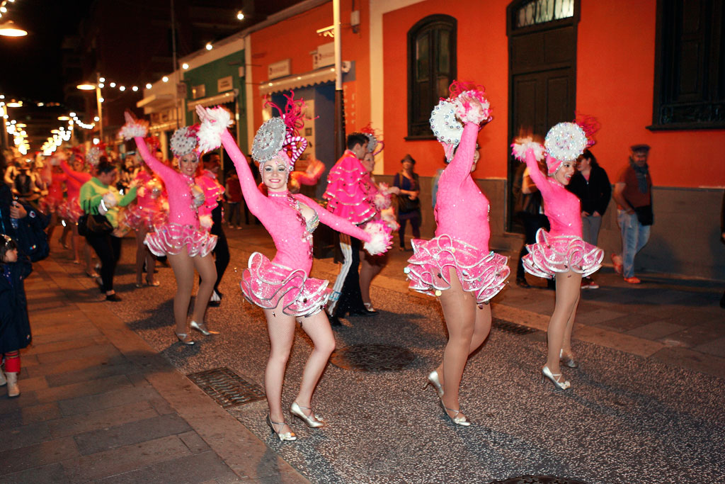 Des danseurs en costumes roses défilent lors d’un carnaval nocturne à Tenerife.