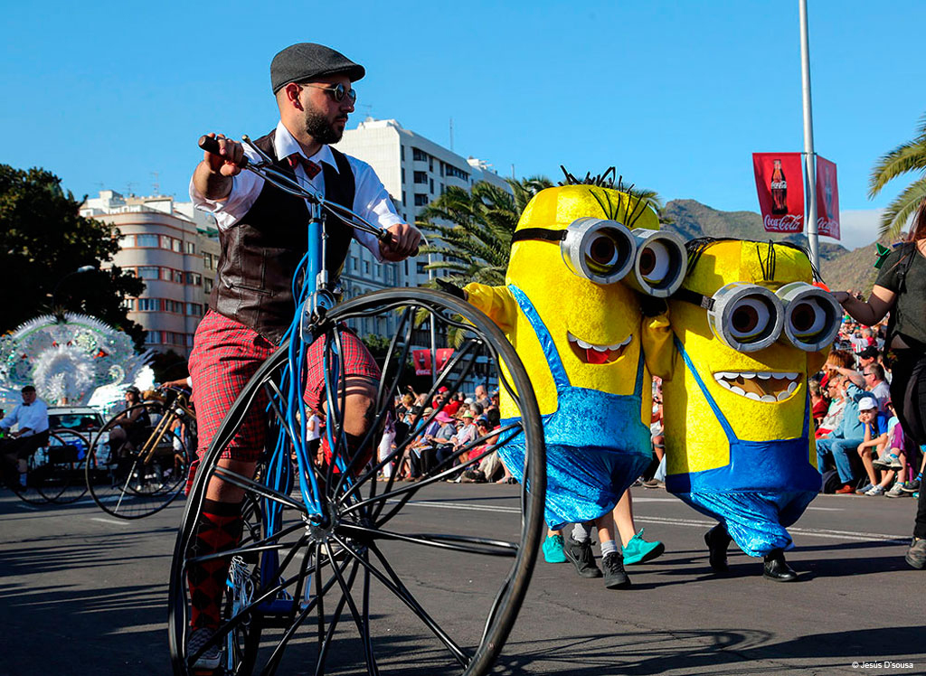 Défilé avec des gens déguisés en personnages jaunes et cyclistes sur un vieux vélo à Tenerife.