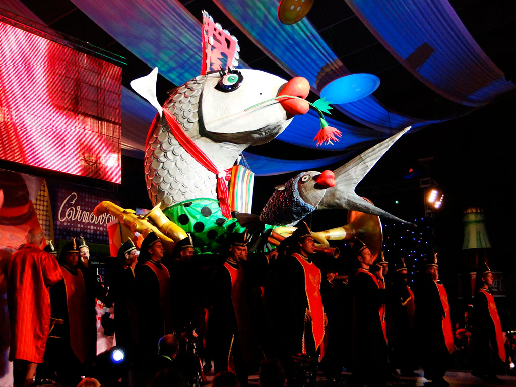 Les poissons flottent au Carnaval de Tenerife, entourés de gens déguisés.