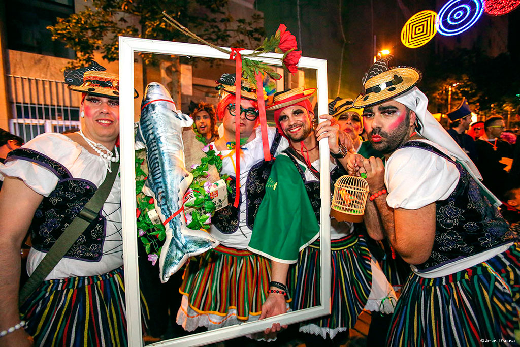 Groupe au carnaval de Tenerife avec des costumes colorés et un cadre décoré.