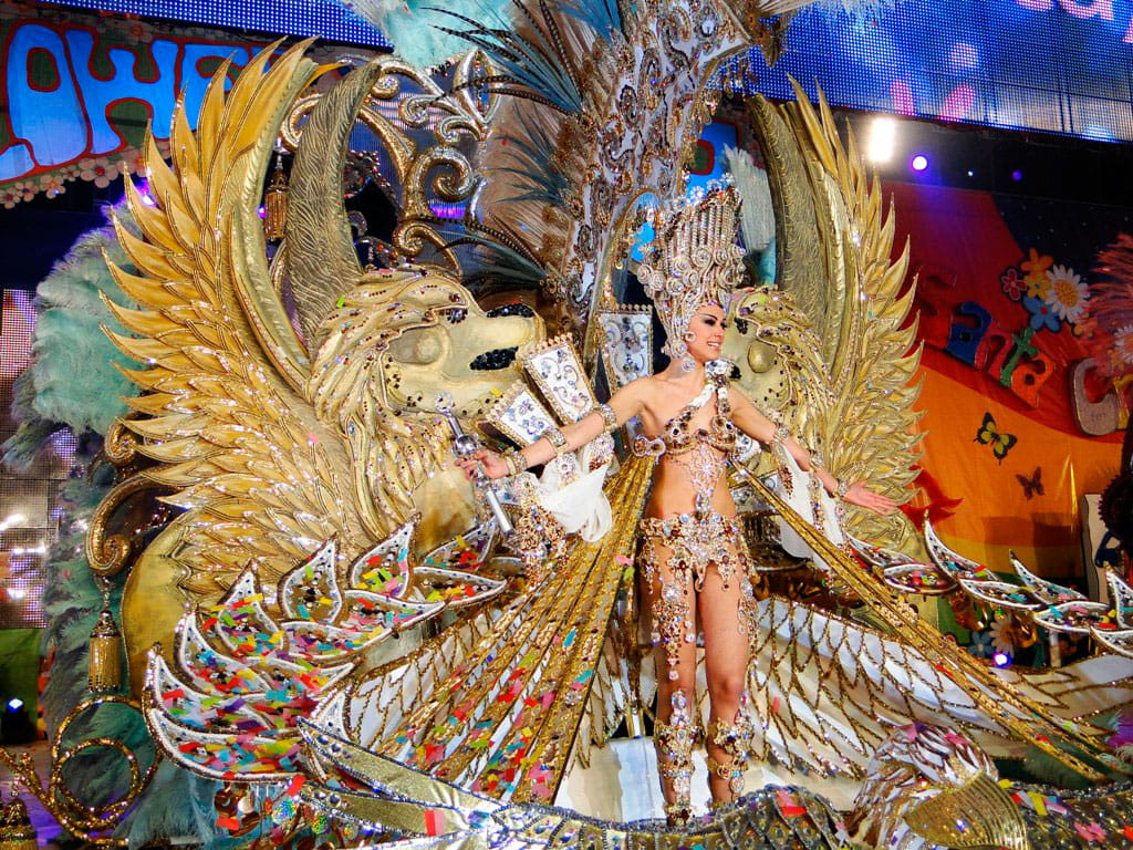 Costume festif au Carnaval de Santa Cruz de Tenerife avec des lions dorés et des plumes.