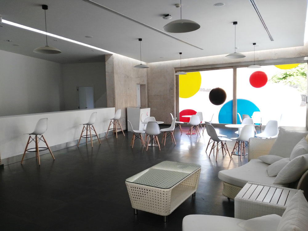 Espace salon moderne avec chaises et tables à côté d’une baie vitrée à Tenerife.
