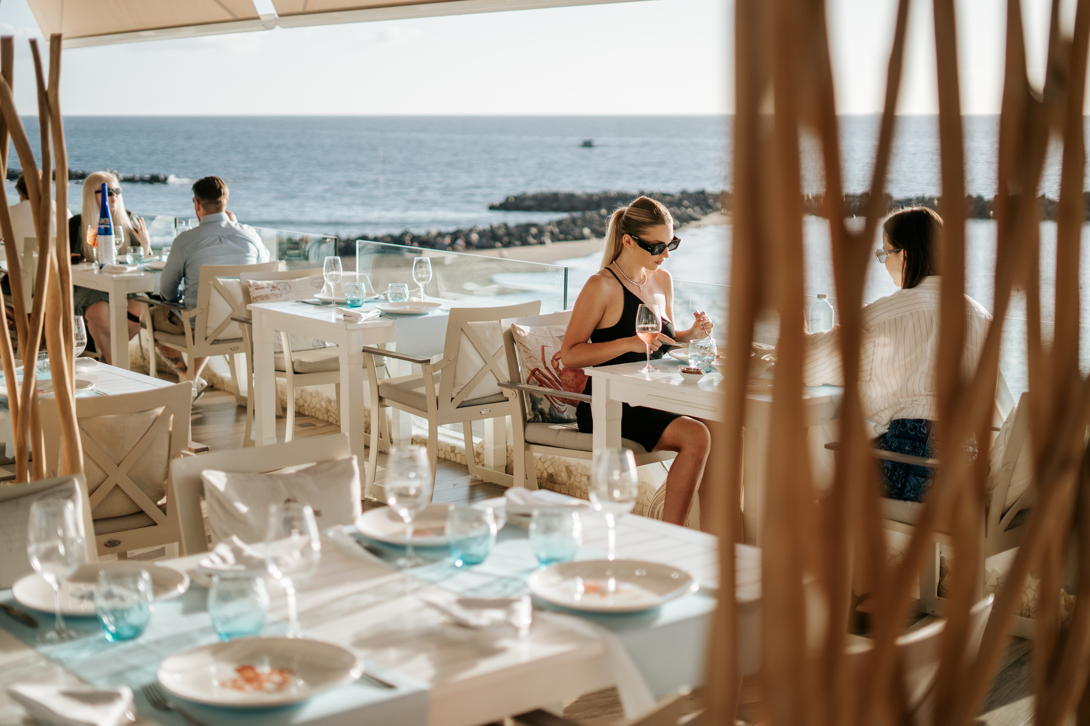 Des gens dînant dans un restaurant donnant sur la mer à Tenerife.