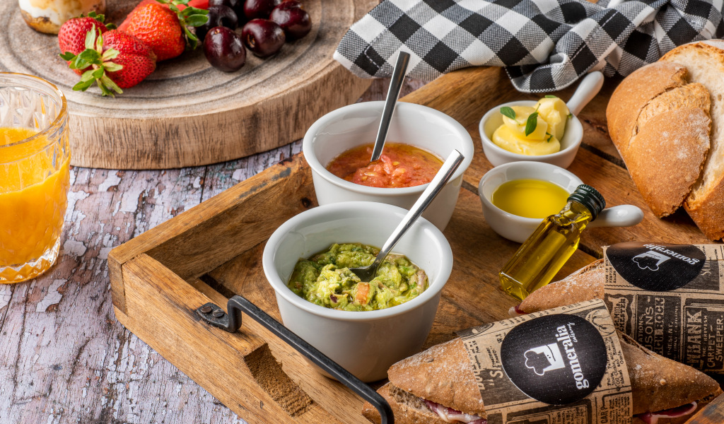 Petit-déjeuner avec fruits, jus d’orange, guacamole, pain et huile d’olive à Tenerife.