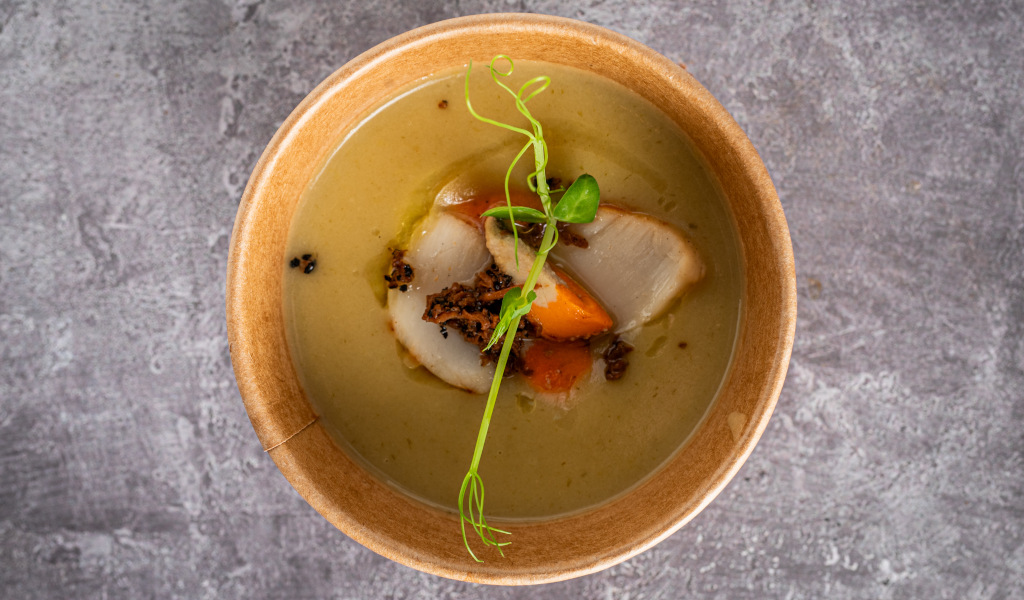 Soupe crémeuse avec légumes et pousses vertes dans un bol sur une table en pierre à Tenerife.