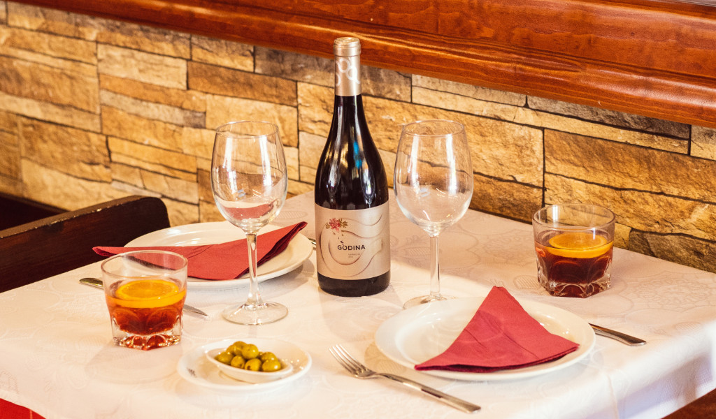 Table dans un restaurant à Tenerife avec verres, bouteille de vin de gondole et verres avec boissons.