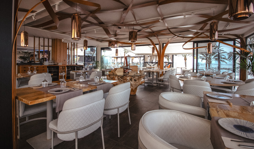 Restaurant élégant avec des tables préparées à Tenerife, vue extérieure avec des palmiers.