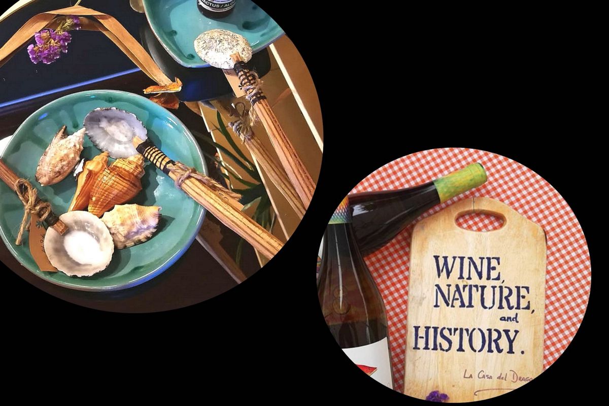 Des assiettes de coquillages et une bouteille à côté d’une table avec le texte VIN, NATURE et HISTOIRE à Tenerife.