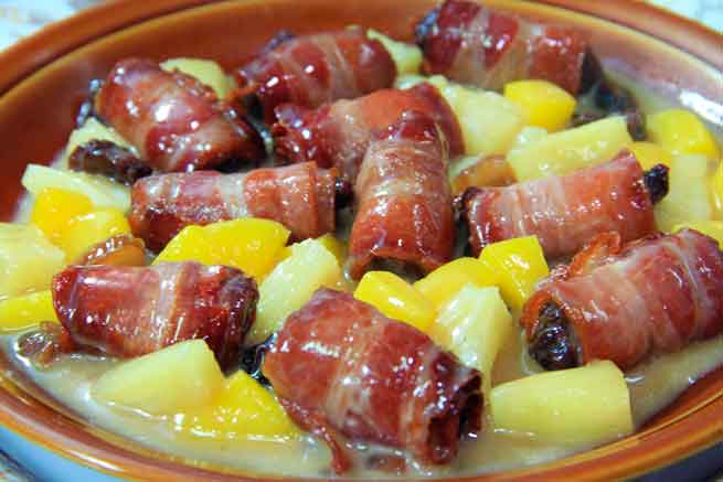 Plat de dattes enveloppées dans du bacon avec des morceaux d’ananas et de mangue à Tenerife.