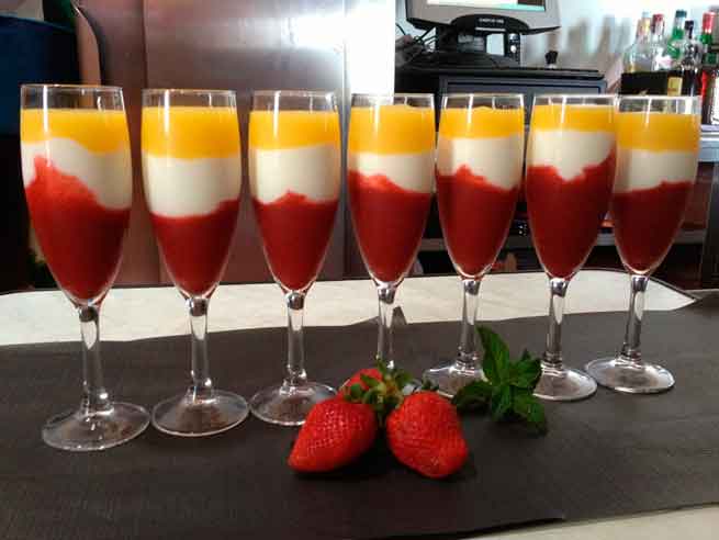 Des verres à dessert avec des couches de fraises et de mangue à côté des fraises à Tenerife.