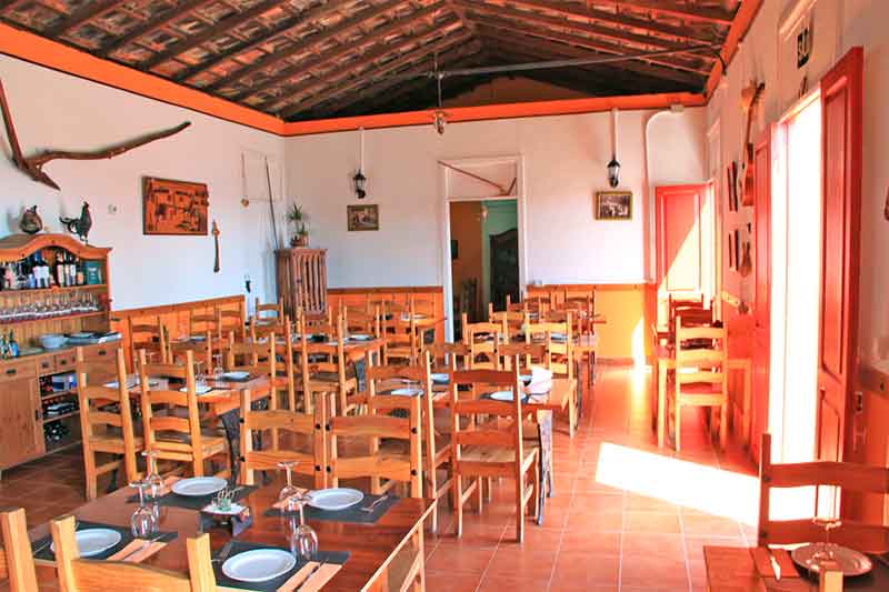 Restaurant rustique à Tenerife avec des tables et chaises en bois disposées.