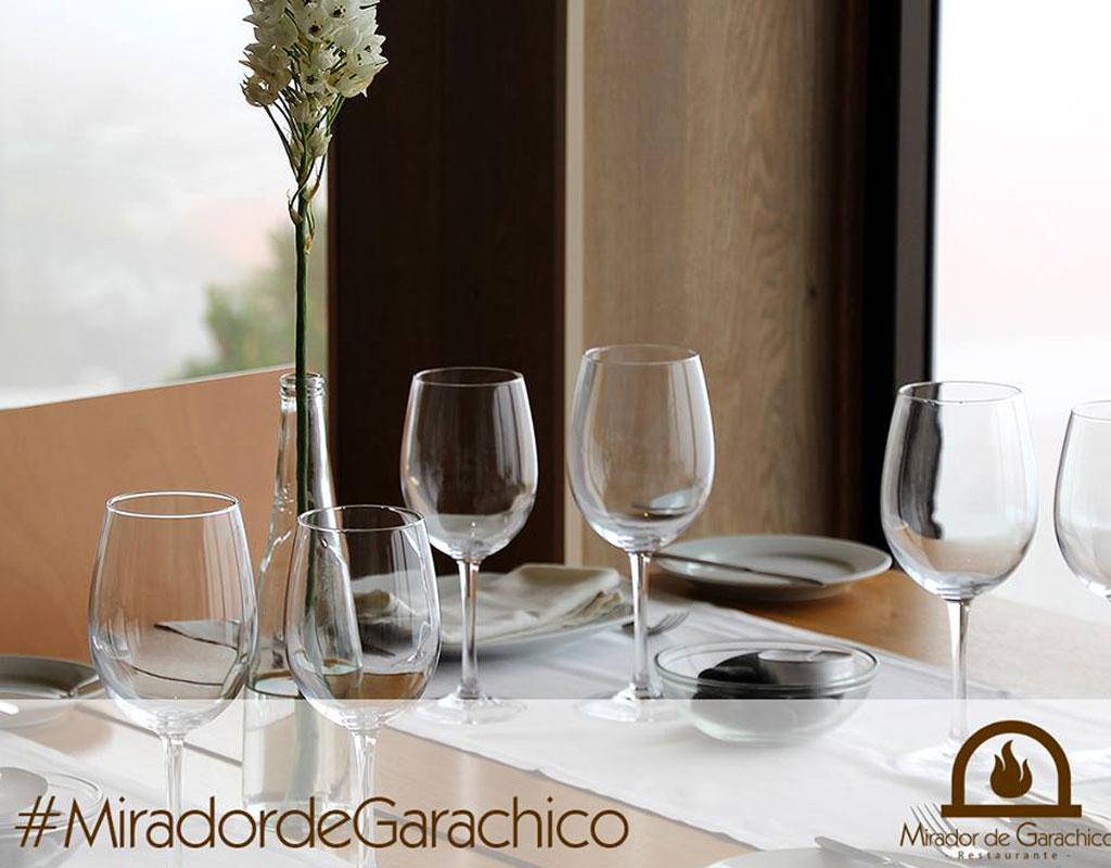 Table avec verres vides et fleurs blanches au restaurant Mirador de Garachico. #MiradordeGarachico