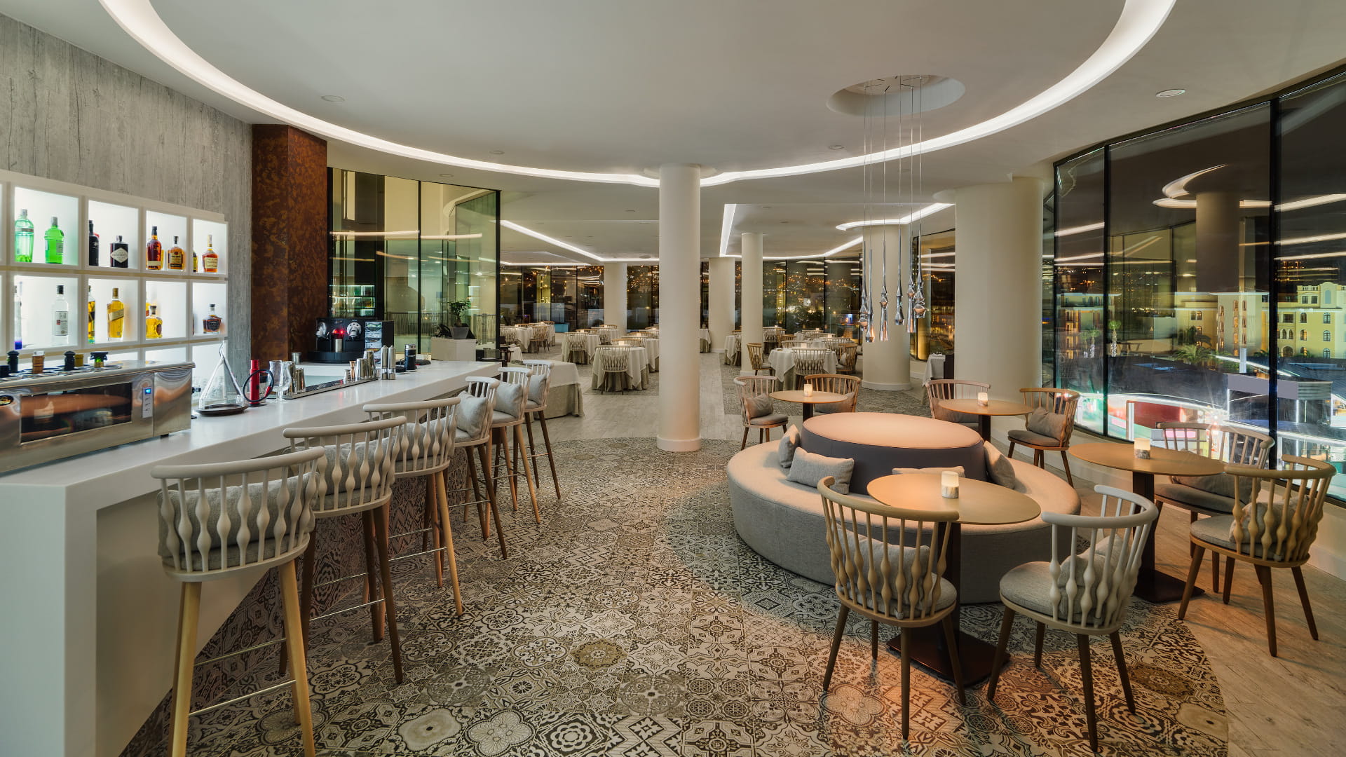 Intérieur d’un restaurant élégant à Tenerife, avec un bar illuminé et des tables avec chaises.