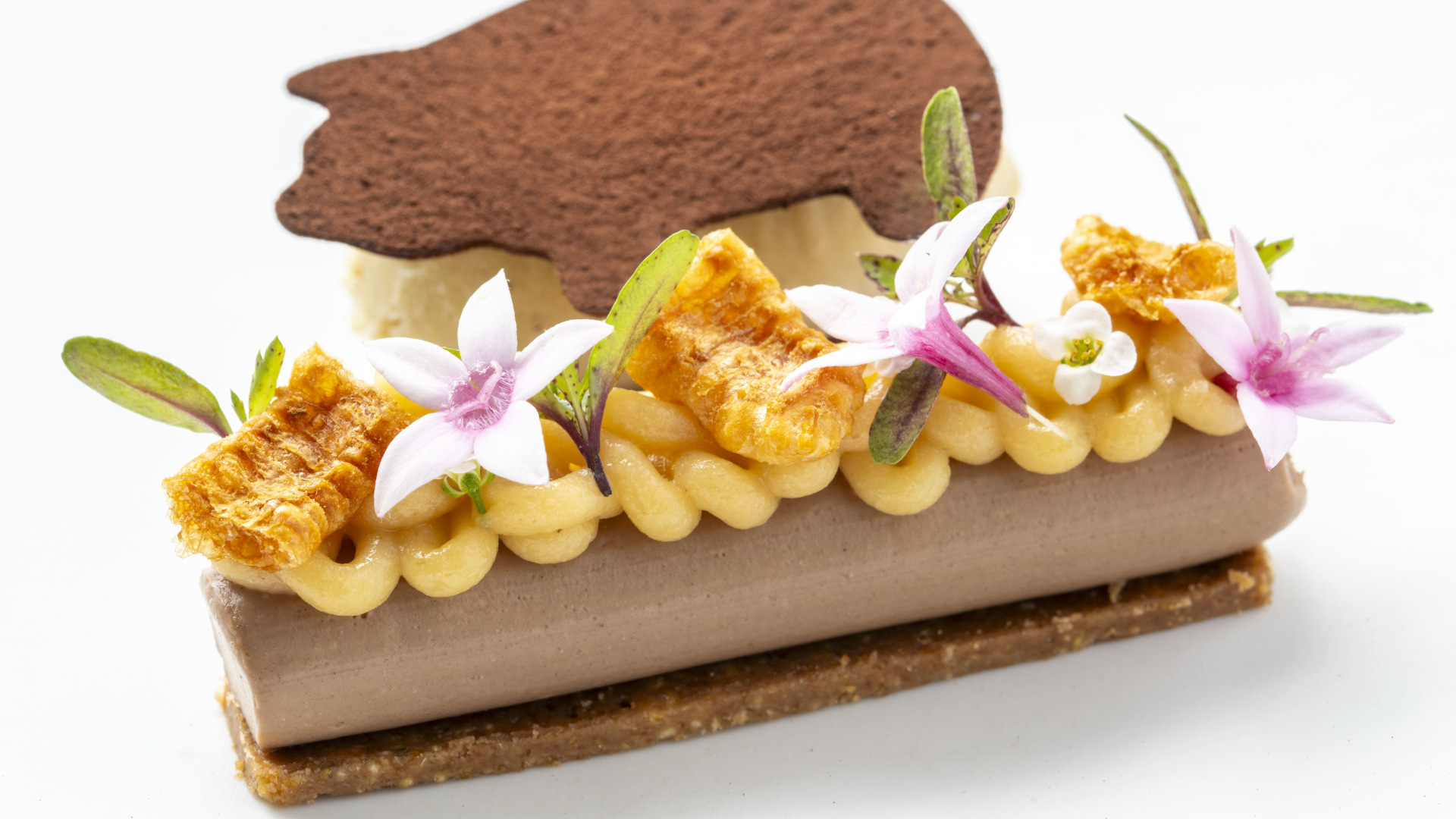 Dessert décoré de fleurs et d’une gaufrette en chocolat à Tenerife.