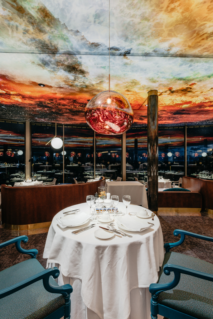 Table avec verres et vaisselle sous un plafond peint dans un restaurant à Tenerife.