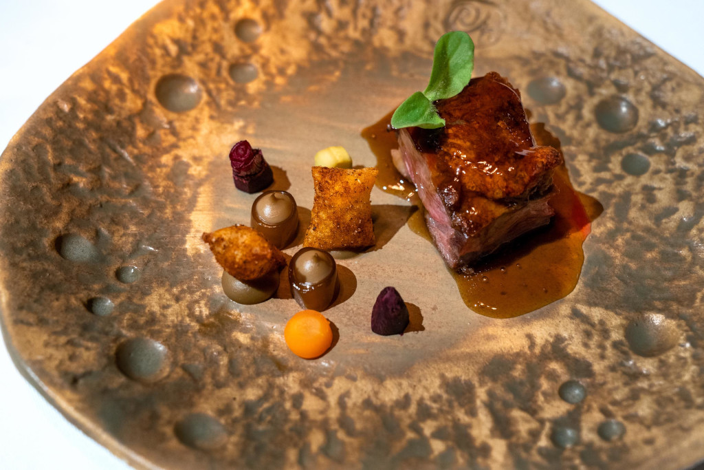 Plat gastronomique avec viande et accompagnements dans un restaurant à Tenerife.
