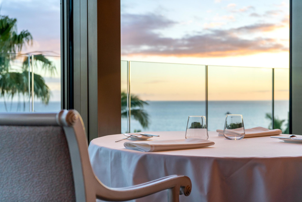 Table avec verres et serviettes, vue sur la mer au coucher du soleil dans un endroit à Tenerife.